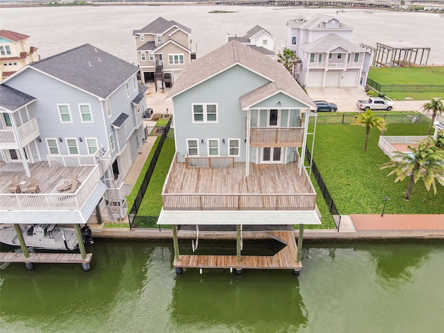 dock area featuring a balcony, a yard, and a water view