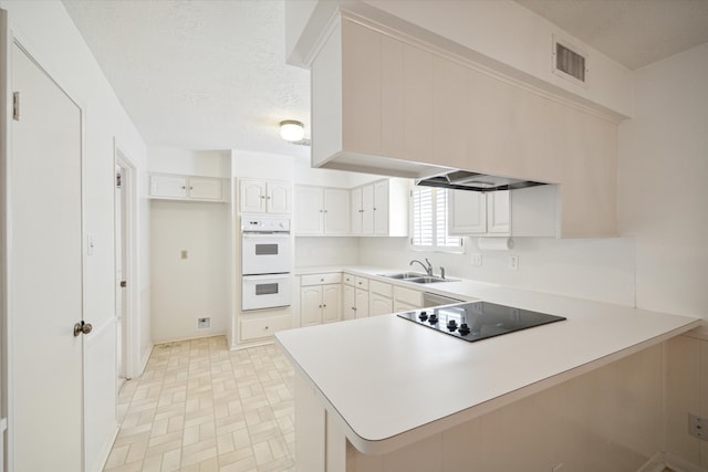 kitchen with double oven, light tile floors, black electric stovetop, white cabinets, and sink