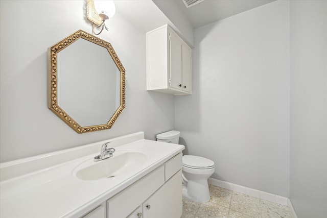 bathroom with tile floors, vanity with extensive cabinet space, and toilet