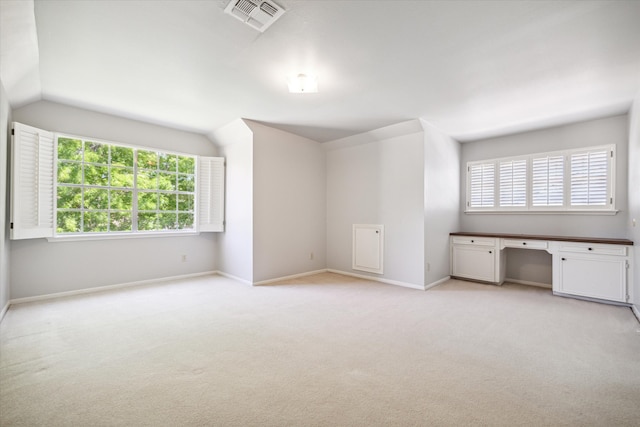 interior space featuring light colored carpet and vaulted ceiling