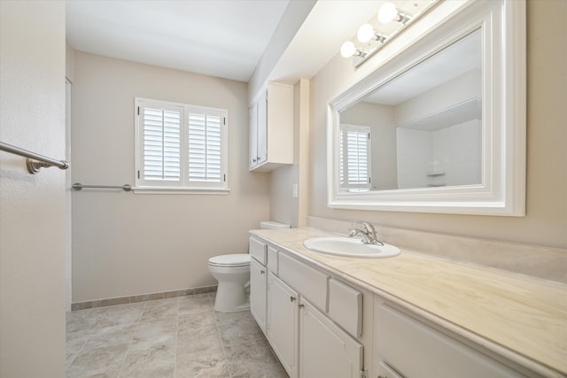 bathroom with toilet, vanity with extensive cabinet space, and tile flooring