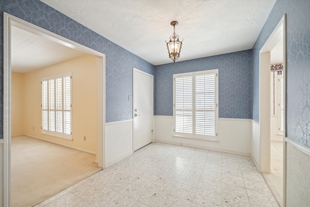 unfurnished room featuring a textured ceiling and light tile floors