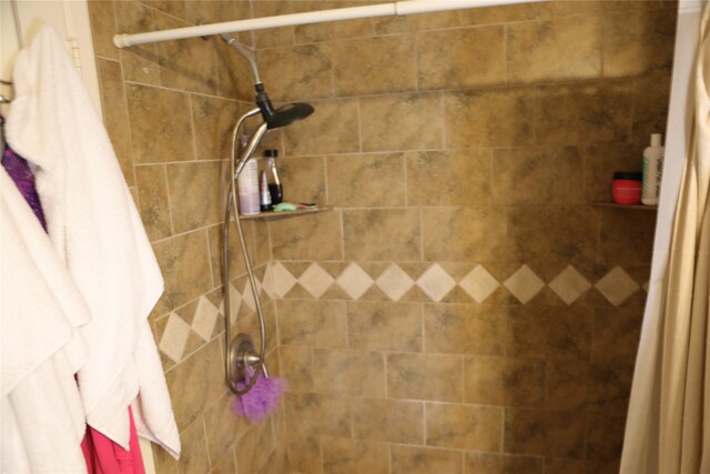 interior details featuring a shower with shower curtain