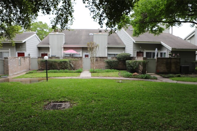 view of front of house featuring a front yard and central AC