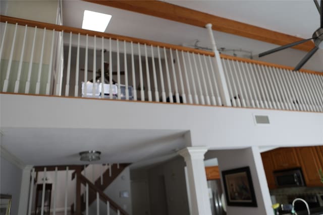 staircase with decorative columns and a high ceiling