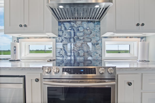 kitchen with white cabinets, stove, and light stone countertops