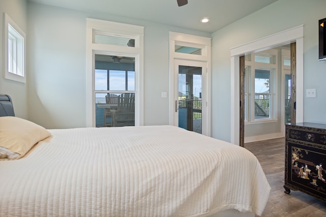 bedroom featuring dark hardwood / wood-style flooring, ceiling fan, and access to outside