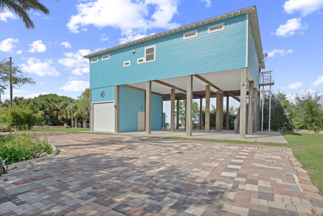 back of house with a patio and a garage