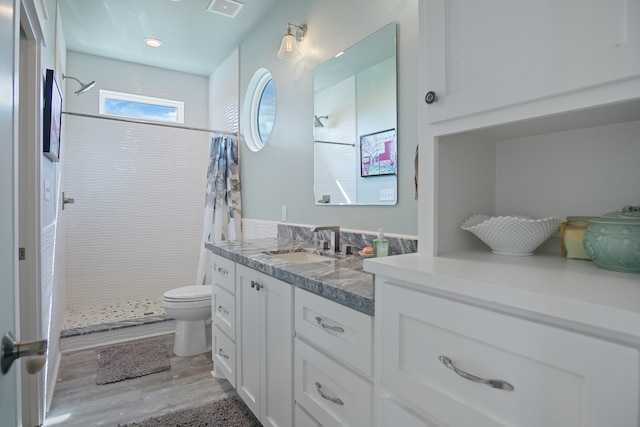 bathroom featuring curtained shower, toilet, vanity, and wood-type flooring