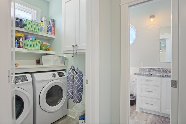 clothes washing area with light hardwood / wood-style flooring, a healthy amount of sunlight, and washer and clothes dryer