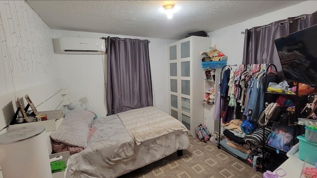 bedroom featuring a textured ceiling, a wall mounted AC, and dark colored carpet