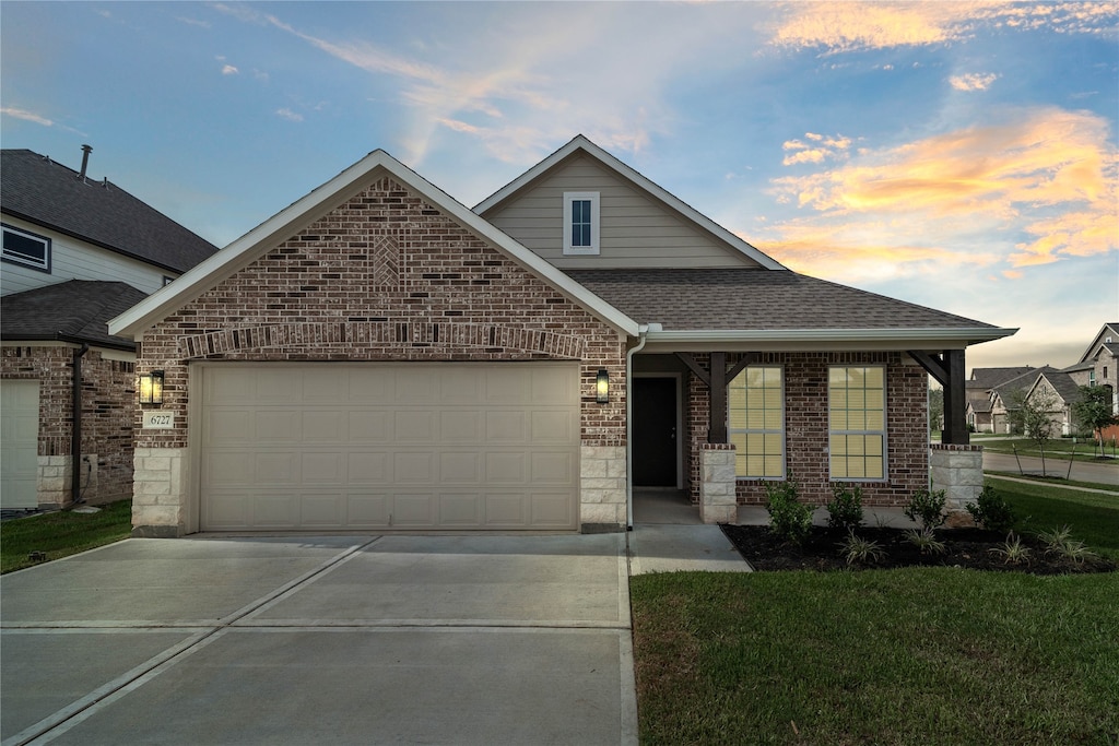 view of front of property with a garage and a yard