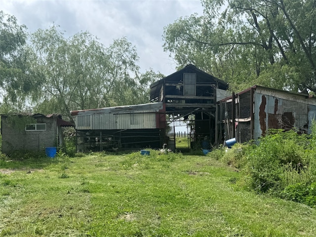 rear view of house with a lawn and an outdoor structure