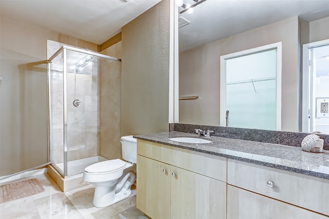 bathroom featuring an enclosed shower, vanity, and toilet