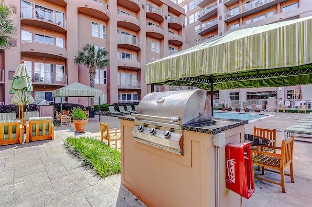 view of patio / terrace featuring a gazebo, a community pool, a balcony, area for grilling, and grilling area