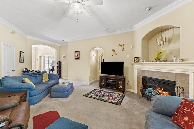 carpeted living room with ornamental molding, ceiling fan, and a fireplace