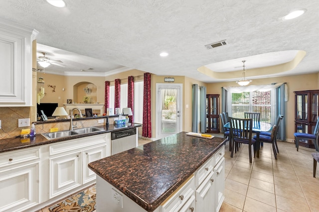 kitchen featuring a raised ceiling, sink, white cabinetry, and dishwasher