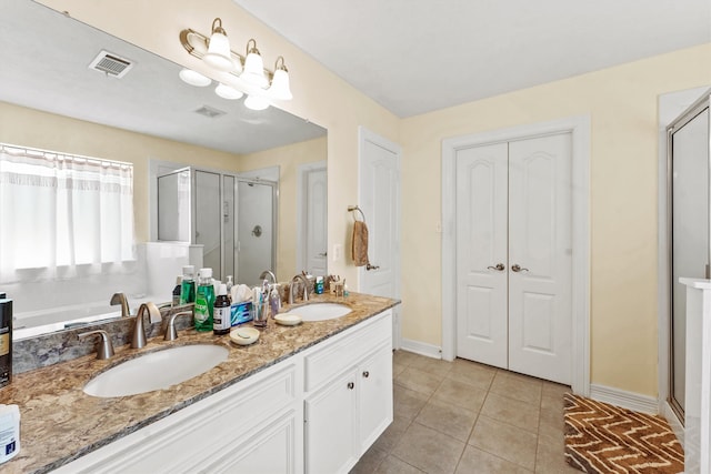 bathroom featuring walk in shower, double sink vanity, and tile floors