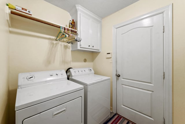 clothes washing area with independent washer and dryer and cabinets