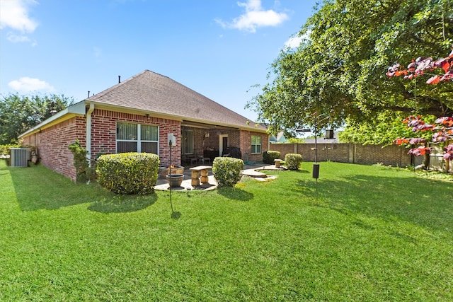 rear view of house with a yard, central air condition unit, and a patio