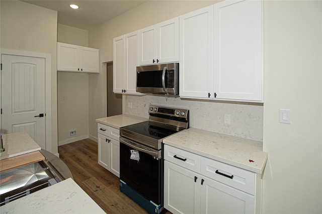 kitchen with dark hardwood / wood-style flooring, white cabinets, tasteful backsplash, and black / electric stove