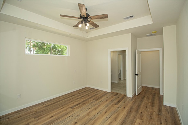 spare room featuring ceiling fan, a raised ceiling, and dark hardwood / wood-style flooring