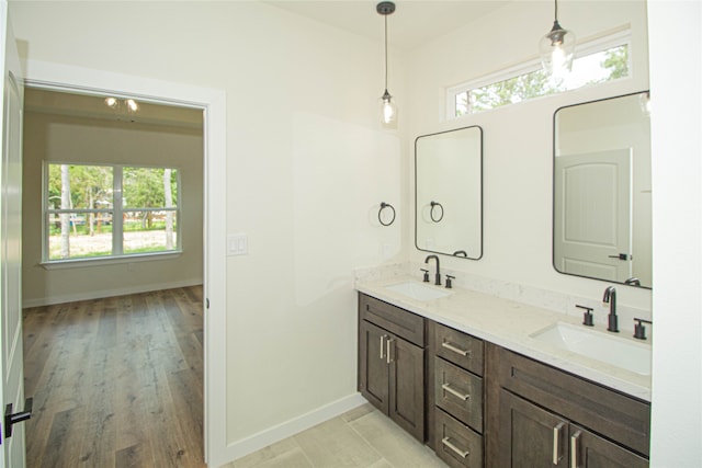 bathroom with vanity with extensive cabinet space, dual sinks, and wood-type flooring