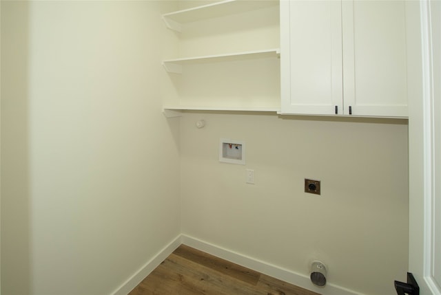 laundry room featuring dark hardwood / wood-style floors, cabinets, hookup for an electric dryer, gas dryer hookup, and washer hookup