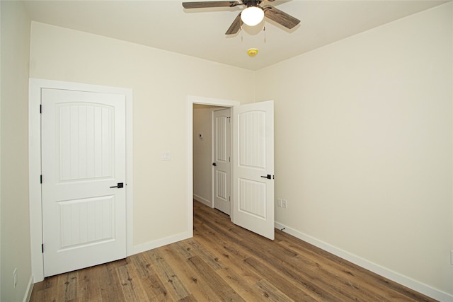 unfurnished bedroom featuring ceiling fan and dark hardwood / wood-style flooring