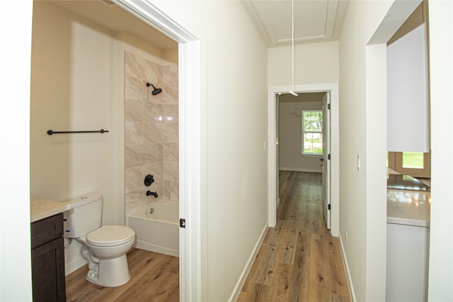 full bathroom with toilet, tiled shower / bath, vanity, and wood-type flooring