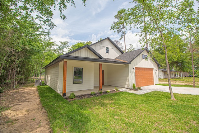 view of front of property with a front lawn, central air condition unit, a porch, and a garage