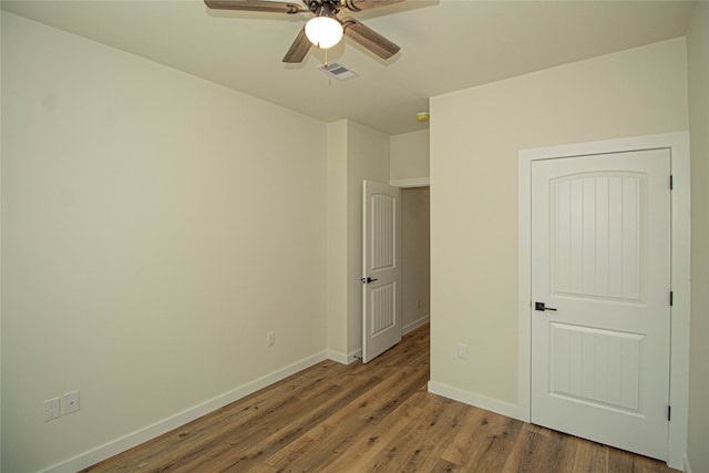 unfurnished bedroom featuring ceiling fan and dark wood-type flooring