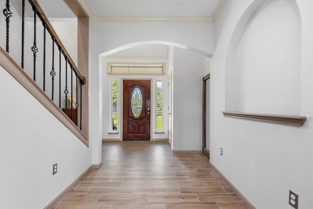 foyer entrance featuring crown molding and light hardwood / wood-style floors