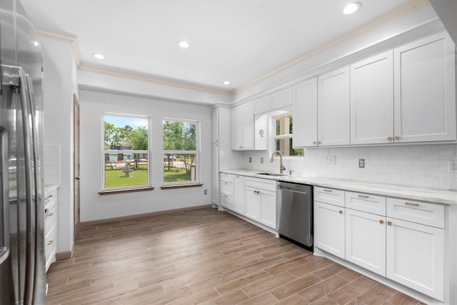 kitchen featuring backsplash, stainless steel appliances, white cabinetry, and sink