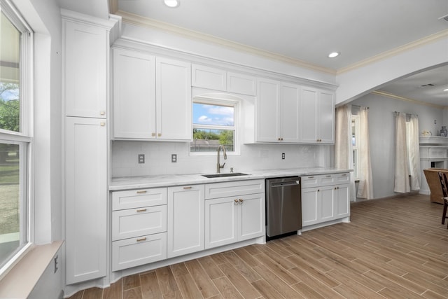 kitchen featuring sink, crown molding, white cabinets, stainless steel dishwasher, and backsplash