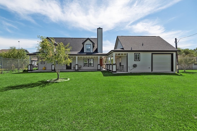 rear view of house featuring a lawn and covered porch