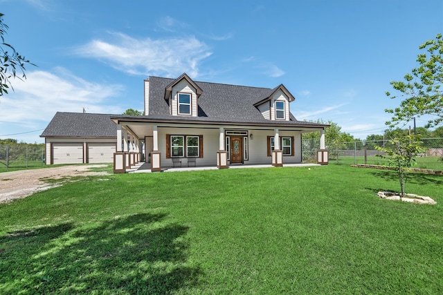 new england style home featuring a porch, a front yard, and a garage