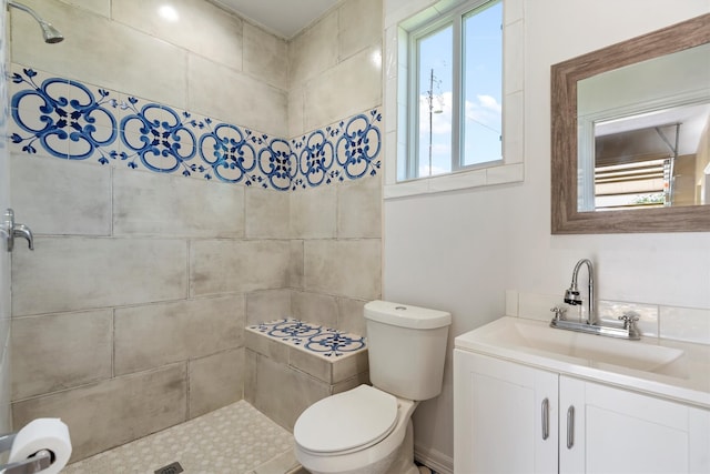 bathroom with toilet, a wealth of natural light, and vanity with extensive cabinet space