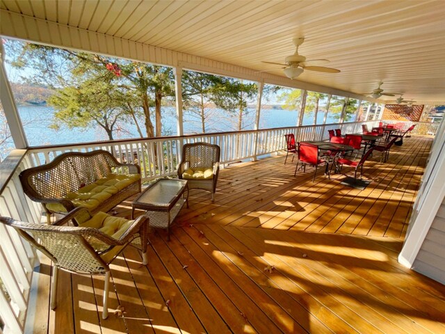 wooden terrace featuring a water view and ceiling fan