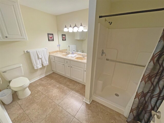 bathroom with a shower, toilet, tile flooring, and double vanity
