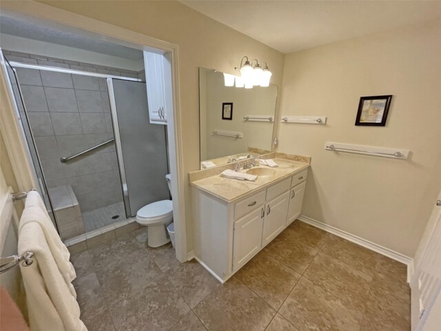 bathroom featuring vanity, tile floors, a shower with door, and toilet
