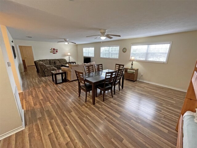 dining space with dark hardwood / wood-style flooring and ceiling fan