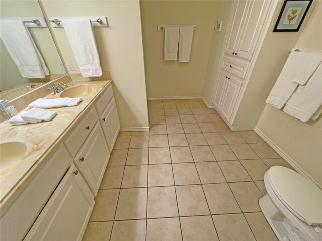 bathroom featuring toilet, tile flooring, and dual bowl vanity