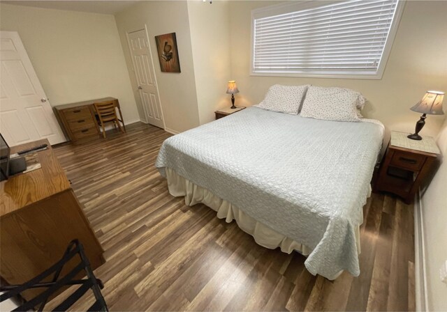 bedroom with dark wood-type flooring