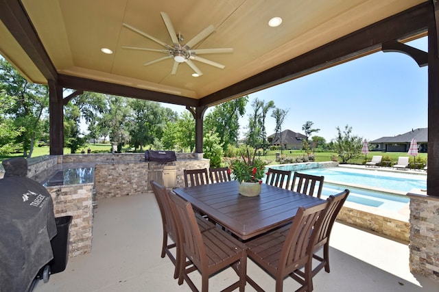 view of patio / terrace with a grill, ceiling fan, and an outdoor kitchen