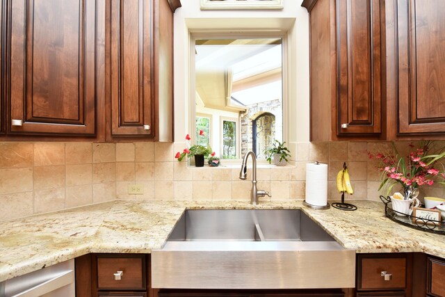 kitchen with sink, tasteful backsplash, and light stone countertops