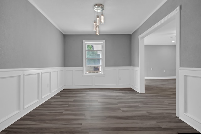 unfurnished room featuring dark wood-type flooring, ornamental molding, and a chandelier