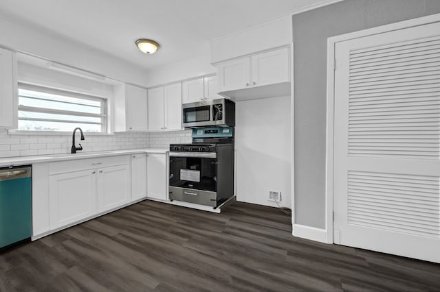 kitchen featuring dark hardwood / wood-style floors, white cabinetry, appliances with stainless steel finishes, and sink