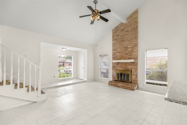 unfurnished living room with ceiling fan, brick wall, high vaulted ceiling, a brick fireplace, and beam ceiling