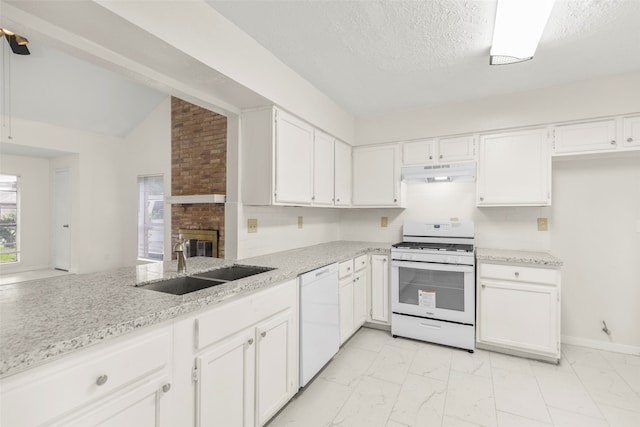 kitchen featuring light stone countertops, a fireplace, white appliances, brick wall, and white cabinets